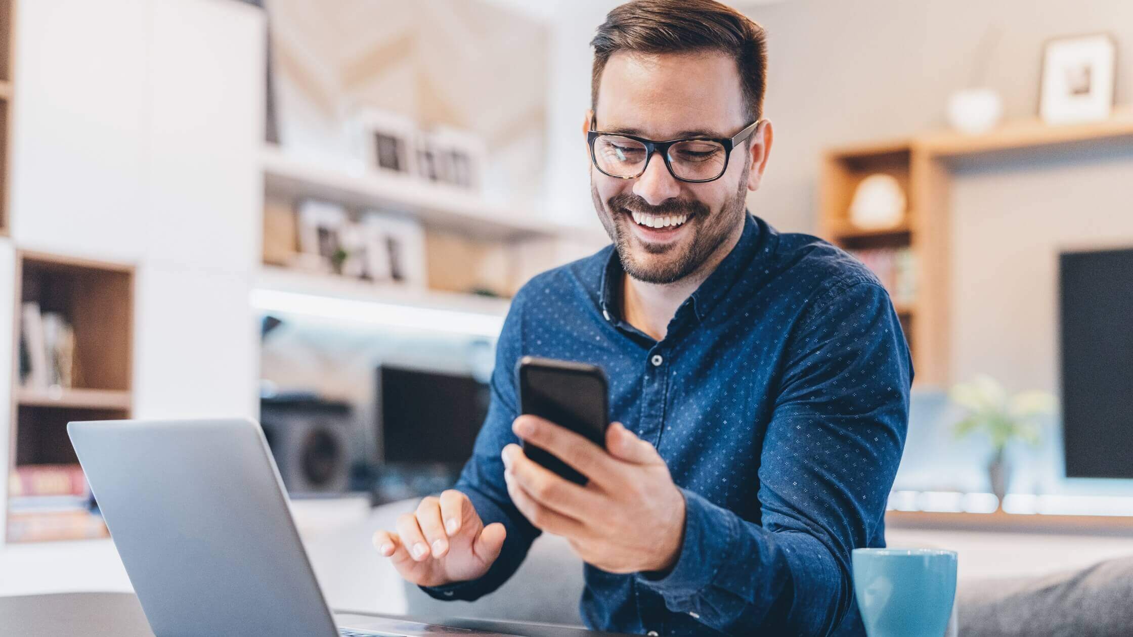 Empresario sonriendo al descubrir las capacidades de ChatGPT en su teléfono inteligente, ejemplificando el aprendizaje y la integración de la inteligencia artificial en la gestión empresarial